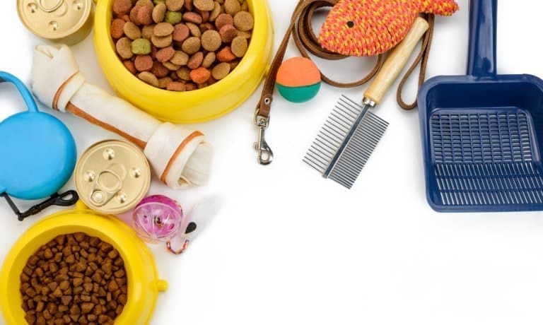 A Quick Guide to Organizing Your Pet Supplies at Home 1 Several pet supplies for dogs and cats, including toys, food, treats, leashes, and grooming supplies, on a white background.