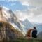 A person sitting next to their dog while resting in front of a scenic mountain view on an outdoor trail.